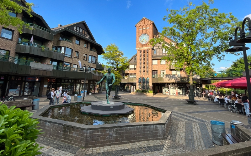 Klemens-Viertel mit Mechanischer Uhr und einem Brunnen im Vordergrund