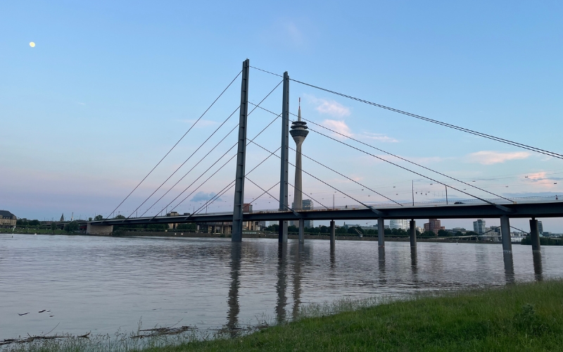 Die Rheinkniebrücke mit dem Rheinturm und dem Medienhafen im Hintergrund