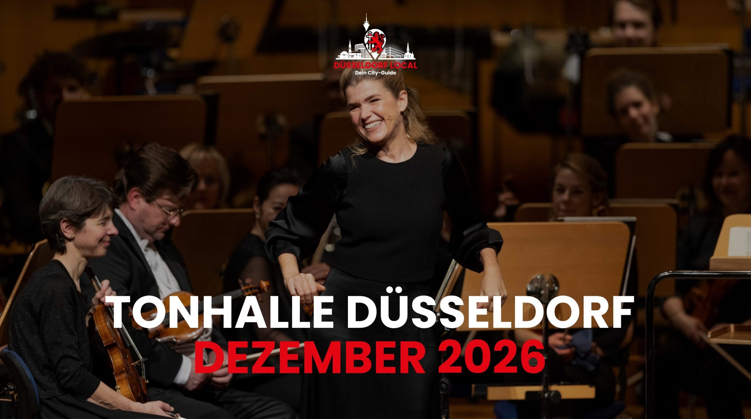 Anke Engelke lächelt auf einer Konzertbühne vor den Musikerinnen und Musikern eines Orchesters; darüber der Titel Tonhalle Düsseldorf Dezember 2026